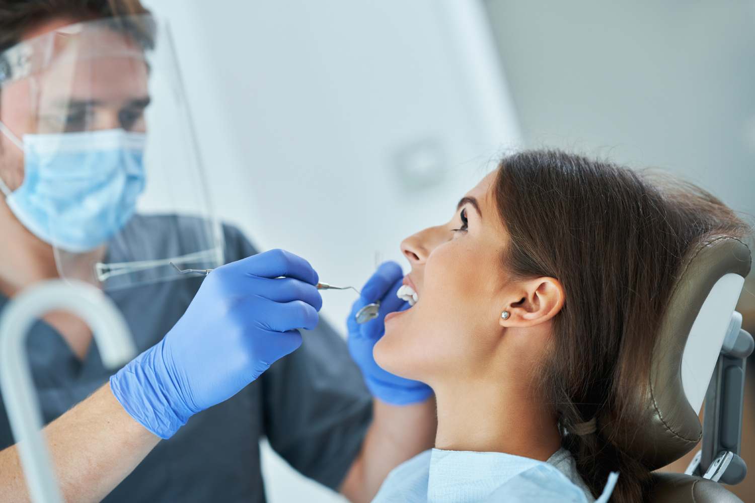 Kobieta siedzi na fotelu dentystycznym u stomatologa